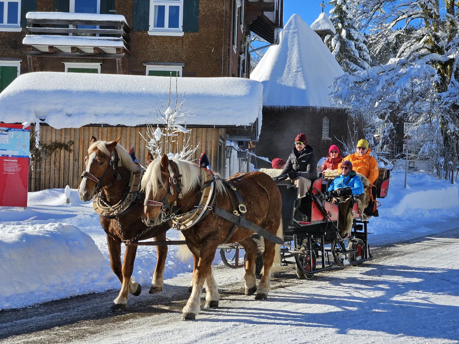 Gäste bei einer Pferdeschlittenfahrt im Winter
