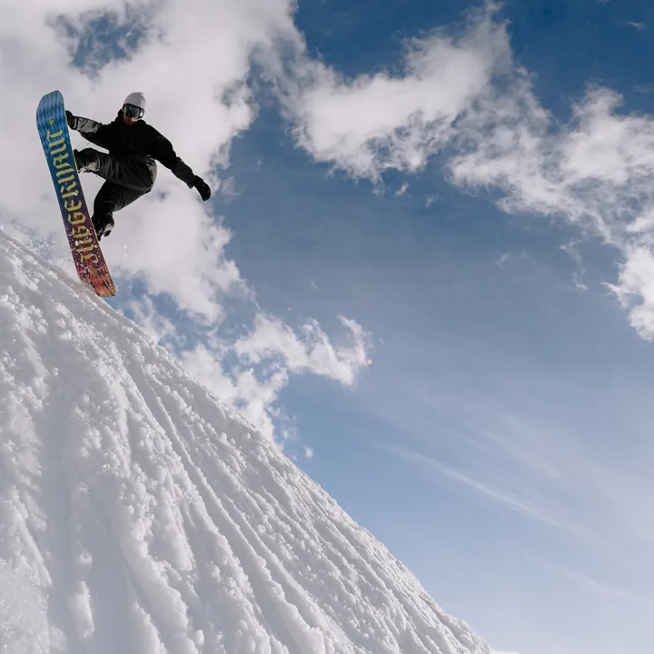 Snowboarder bei einem Sprung im Tiefschnee